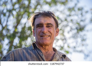 Farmer middle-aged man with wrinkles on his face. Sun light.