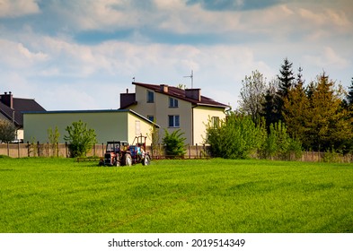 Farmer On A Red Tractor Spraying A Farmland