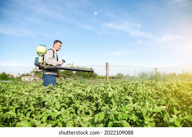 A Farmer With A Pesticide Sprayer Machine Walks Across The Field. Protection Of Plants From Insects And Fungal Infections. Chemical Industry In Farming Agriculture. Resistance Of The Crop To Pests.