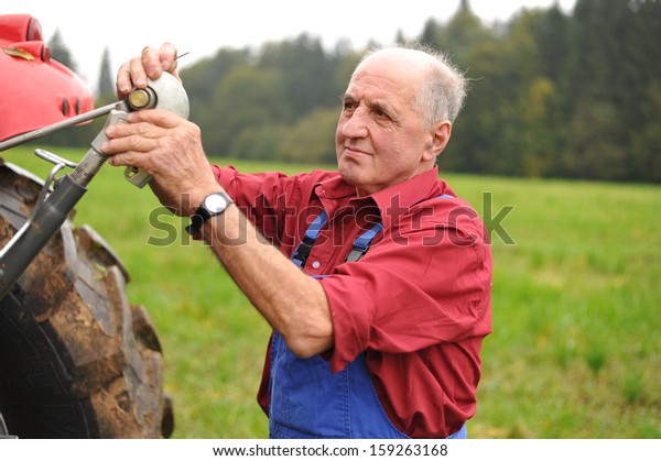 Farmer\
repairing his red tractor, model is real farmer\
