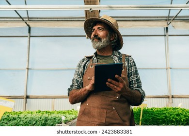 Farmer senior man working in his farm and greenhouse. Concept about agriculture, farn industry, and healthy lifestyle during seniority age - Powered by Shutterstock