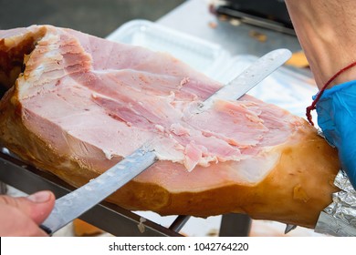 Farmer Slicing with Long Knife Smoked Baked Pork Ham from Leg at Market. Close up of Meat Texture. Vibrant Colors. Organic Produce. Travel Lifestyle. Authentic Atmosphere. Top View - Powered by Shutterstock