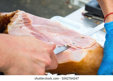 Farmer Slicing with Long Knife Smoked Baked Pork Ham from Leg at Market. Close up of Meat Texture. Vibrant Colors. Organic Produce. Travel Lifestyle. Authentic Atmosphere - Powered by Shutterstock