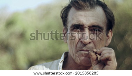 Farmer smoking a cigarette on the farm, straw cigarette