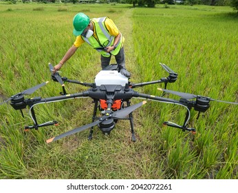 Farmer technicians prepare to remotely fly agricultural drones to fly to spray fertilizer in rice fields. Agricultural technology smart farm concept. - Powered by Shutterstock