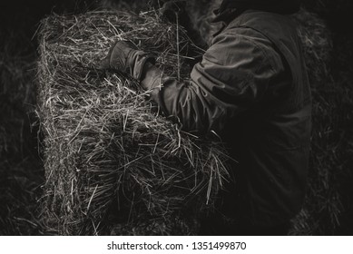 Farmer Throwing Hay Bale