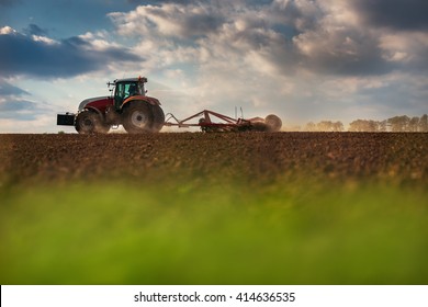 Farmer in tractor preparing land with seedbed cultivator, sunset shot - Powered by Shutterstock