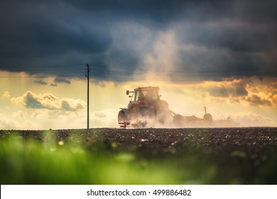 Farmer in tractor preparing land with seedbed cultivator, sunset shot - Shutterstock ID 499886482