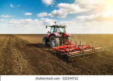 Farmer in tractor preparing land with seedbed cultivator as part of pre seeding activities in early spring season of agricultural works at farmlands. - Shutterstock ID 532194712