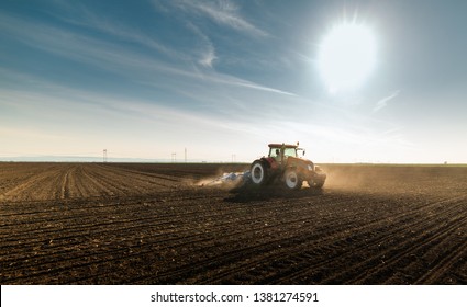  Farmer With Tractor Seeding  Crops At Agricultural Field