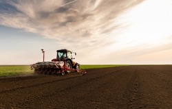 Farmer With Tractor Seeding - Sowing Crops At Agricultural Fields In Spring