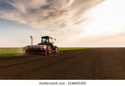 Farmer with tractor seeding - sowing crops at agricultural fields in spring - Shutterstock ID 2148455303