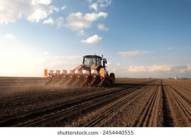 Farmer with tractor seeding - sowing crops at agricultural field. Plants, wheat. - Powered by Shutterstock