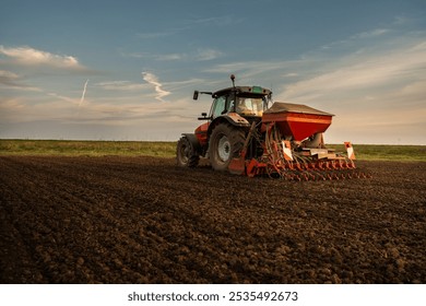 Farmer with tractor seeding - sowing crops at agricultural field. Plants, wheat.