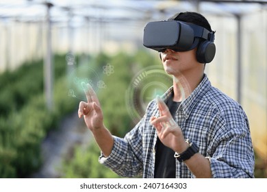 Farmer wearing VR headset for controlling process in greenhouse cultivation. Modern and smart agriculture concept. - Powered by Shutterstock