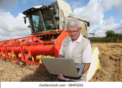 Farmer in wheat field with harvester