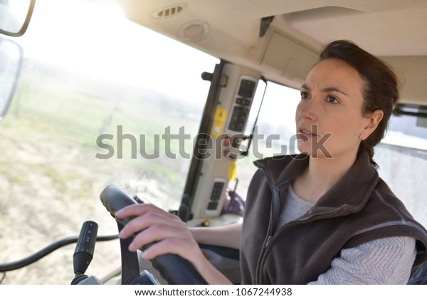 Farmer woman driving\
tractor