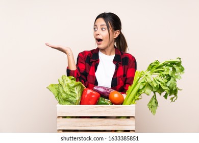Farmer Woman holding fresh vegetables in a wooden basket holding copyspace imaginary on the palm