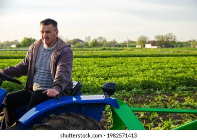 The farmer works in the field with a tractor. Harvesting crops campaign, earthworks. Agro industry, agribusiness. Countryside farmland. Farming, agriculture. Harvesting potatoes in early spring. - Shutterstock ID 1982571413