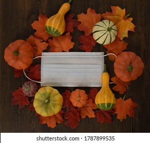 Farmers Market During Pandemic.  
Medical Mask And Vegetables Between Maple Leaves On The Wooden Background.  Top View. Fall2020. 