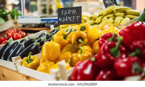 Farmers Market Food Stall with a Selection of Ecological Fruits and Vegetables. Organic Red and Yellow Bell Peppers, Fresh Eggplants, Bio Bananas and Other Groceries on the Outdoors Stand with Sign - Powered by Shutterstock