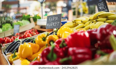 Farmers Market Food Stall with a Selection of Ecological Fruits and Vegetables. Organic Red and Yellow Bell Peppers, Eggplants, Natural Chemical-Free Bananas and Other Groceries on the Outdoors Stand - Powered by Shutterstock