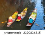 Farmers row boats at the floating market selling local Thai food. Organic vegetables and fruits and Thai tourism culture concept The famous Damnoen Saduak Floating Market of Ratchaburi Province.