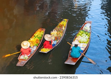Farmers row boats at the floating market selling local Thai food. Organic vegetables and fruits and Thai tourism culture concept The famous Damnoen Saduak Floating Market of Ratchaburi Province.