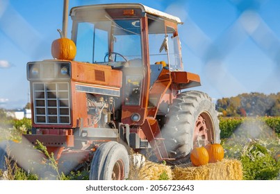 A Farmer's Tractor Displays An Autumn Bounty In Countryside. A Tractor Decorated With Hay And Pumpkins For Thanksgiving Day And Halloween Festival. Street Photo, Selective Focus, Travel Photo, Nobody