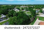 Farmhouse on large acres land lush greenery trees, high school baseball field in Fairland agriculture town, aerial view agro-town in Ottawa County, Oklahoma near U.S. Highway 60, aerial view. USA