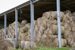 A Farming Barn With Stacked Round Hay Bales 