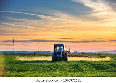 Farming tractor plowing and spraying on field