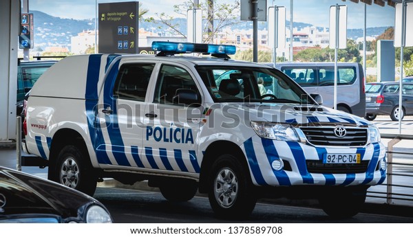Faro, Portugal\
- May 3, 2018: Portuguese police car parked in front of Faro\
International Airport on a spring\
day