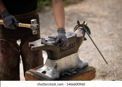 Farrier at work with iron horseshoe