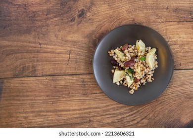 Farro Salad With Artichokes And Olives On A Wooden Background