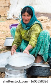 Fars Province, Iran – April 8, 2019: Qashqai woman cleaning dishes, Qashqai nomad camp, Fars Province, Iran
