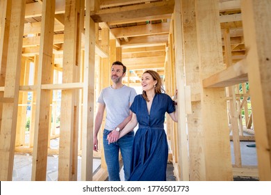 Fascinated couple walking in their new house under construction, dreams come true