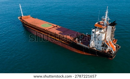 Fascinating high angle photograph capturing a large industrial bulk cargo ship navigating the marine environment for global import and export delivery.