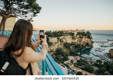 Fascinating lady standing at viewpoint and take photo Principality of Monaco, sightseeing the stunning skyline of sea and panorama Monaco.