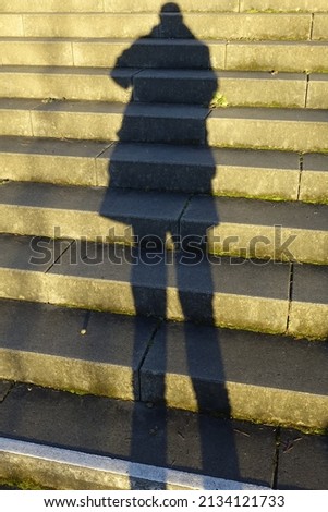 Fascinating light and shadow play, steep concrete stairs, shadow cast of me as photographer, deep winter sun, concept: solitude, foreshadow, challenge, threat (vertical), Kaiserslautern, Germany