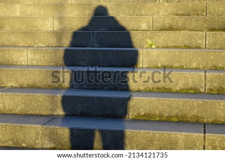 Fascinating light and shadow play, steep concrete stairs, shadow cast of me as photographer, deep winter sun, concept: solitude, foreshadow, challenge, threat (horizontal), Kaiserslautern, Germany