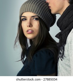 Fascinating woman looking to the camera next to young attractive man kissing her on the head