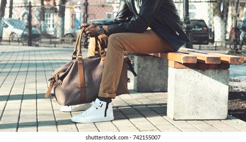 Fashion African Man Holding Bag Sitting On  Bench In City Park Close Up, Male Accessory 