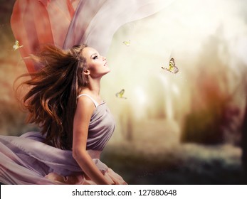 Fashion Art Beauty Portrait. Beautiful Girl in Fantasy Mystical and Magical Spring Garden. Model Woman wearing Long Chiffon dress