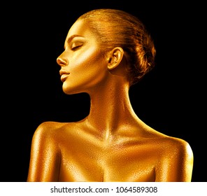 Fashion art Golden skin Woman face portrait closeup. Model girl with holiday golden Glamour shiny professional makeup. Gold jewellery, jewelry, accessories. Beauty gold metallic body, Lips and Skin