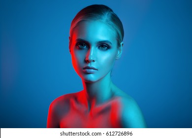 Fashion Art Portrait Of Beautiful Woman Face. Red And Blue Light Color.