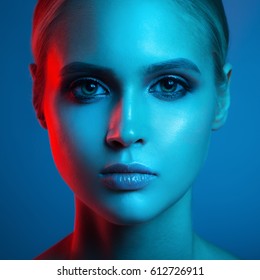 Fashion Art Portrait Of Beautiful Woman Face. Red And Blue Light Color.