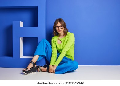 Fashion Asian Female Model In Green Trendy Top And Blue Pants. Studio Shot