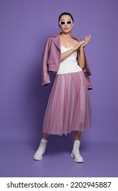 Fashion Asian Female Model. Lilac Leather Jacket, Lilac Skirt, White Boots, Sunglasses. Asian Fashion