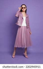 Fashion Asian Female Model. Lilac Leather Jacket, Lilac Skirt, Heels, Sunglasses. Asian Fashion